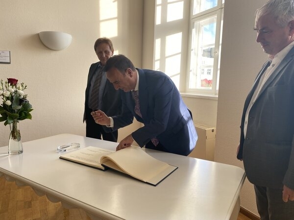 Bild vergr&ouml;&szlig;ern: Ilir Xhakolli trägt sich ins Goldene Buch der Hansestadt Wismar ein.