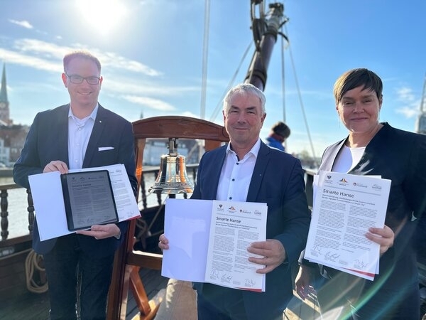 Bild vergr&ouml;&szlig;ern: Jan Lindenau (l.), Thomas Beyer und Eva-Maria Kröger mit den unterzeichneten Absichtserklärungen für eine städteübergreifende Zusammenarbeit bei der Digitalen Transformation zur "Smart City".