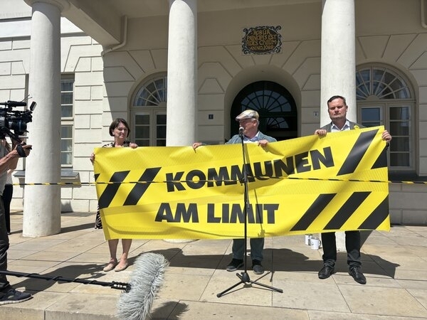 Protest vor dem Rathaus in Wismar: Senatorin Heike Bansemer, Bürgermeister Thomas Beyer (M.) und Senator René Domke mit einem Banner "Kommunen am Limit".
