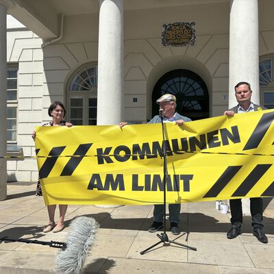 Bild vergr&ouml;&szlig;ern: Protest vor dem Rathaus in Wismar: Senatorin Heike Bansemer, Bürgermeister Thomas Beyer (M.) und Senator René Domke mit einem Banner "Kommunen am Limit".