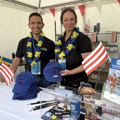 Bild vergr&ouml;&szlig;ern: Christine Ennen und Hugo Alfonso Eguia Contreras von der Stadtverwaltung bieten am Stand der Tourismuszentrale auf dem Marktplatz Schwedenfest-Souvenirs an.