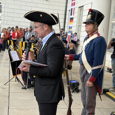Bild vergr&ouml;&szlig;ern: Bürgermeister Frank Junge (Mitte) mit einem Dreispitz, den er von den Bohus Elfsborghs Caroliner erhalten hatte.