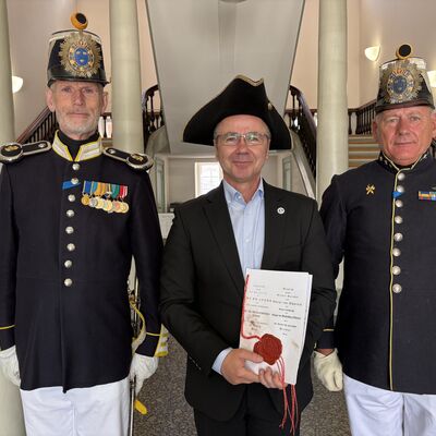 Bild vergr&ouml;&szlig;ern: Bürgermeister Frank Junge (Mitte) mit einem Dreispitz, den er von den Bohus Elfsborghs Caroliner erhalten hatte.