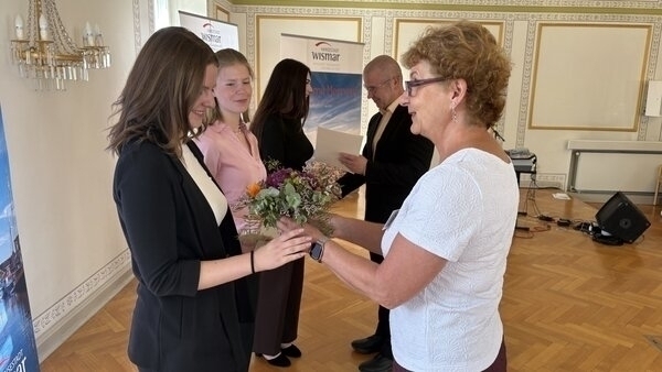 Birte Weiss (r.) aus dem Amt für Personal, Organisation und IT überreicht Blumen und Bürgermeister Frank Junge die Ausbildungszeugnisse an Lilly Jablinski, Lena Limpack und Lelaina Herzog (v.l.).