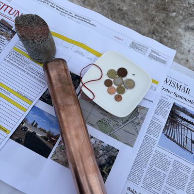 Bild vergr&ouml;&szlig;ern: Münzen, Pläne und Kopien von Zeitungsseiten für die Zeitkapsel.