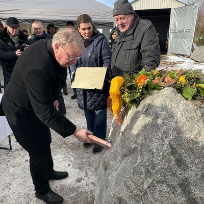 Bild vergr&ouml;&szlig;ern: Frauke und Onno Folkerts schauen zu, wie Senator Michael Berkhahn die Zeitkapsel in den Stein schiebt.
