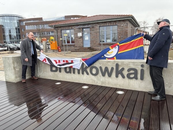 Dr. Wolfgang Blank (l.), Minister für Wirtschaft, Infrastruktur, Tourismus und Arbeit Mecklenburg-Vorpommern, und Senator Michael Berkhahn enthüllen den Schriftzug "Brunkowkai" an der Kaimauer.