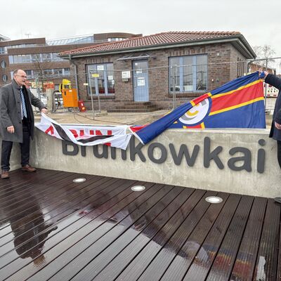 Bild vergr&ouml;&szlig;ern: Dr. Wolfgang Blank (l.), Minister für Wirtschaft, Infrastruktur, Tourismus und Arbeit Mecklenburg-Vorpommern, und Senator Michael Berkhahn enthüllen den Schriftzug "Brunkowkai" an der Kaimauer.
