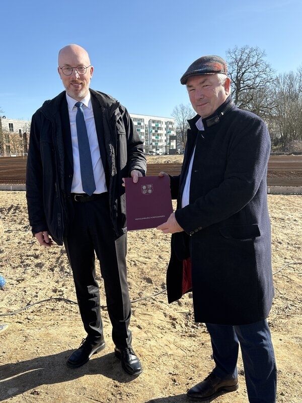 Minister Christian Pegel (l.) überreicht einen Zuwendungsbescheid an Bürgermeister Thomas Beyer.